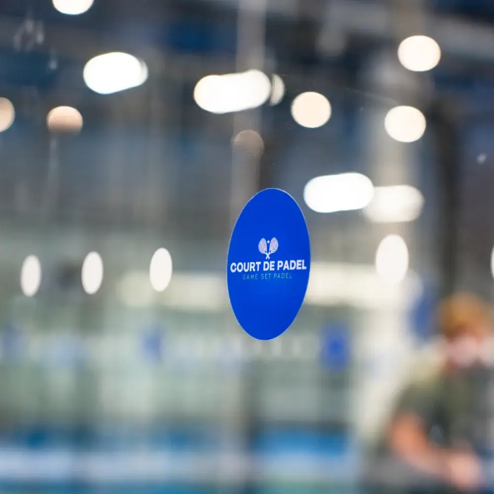 Court De Padel branded glass marker on an indoor padel court