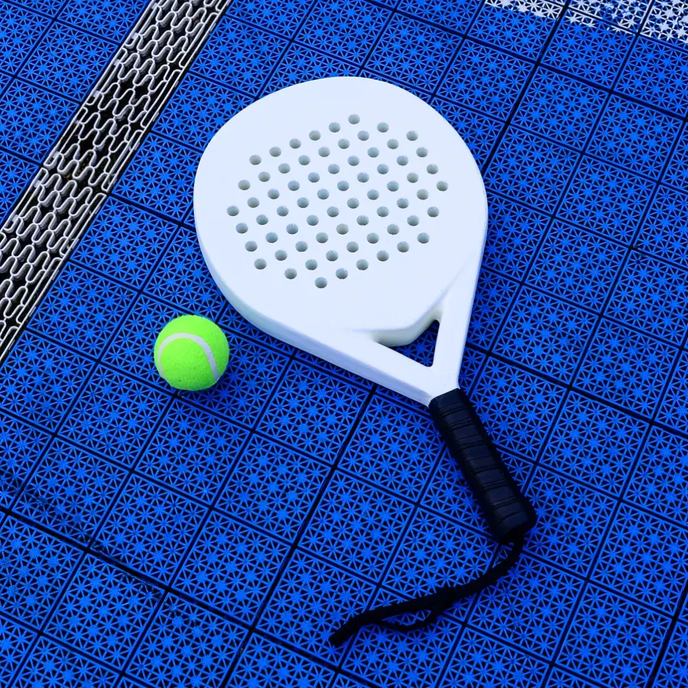 White padel racket and ball resting on a blue padel court